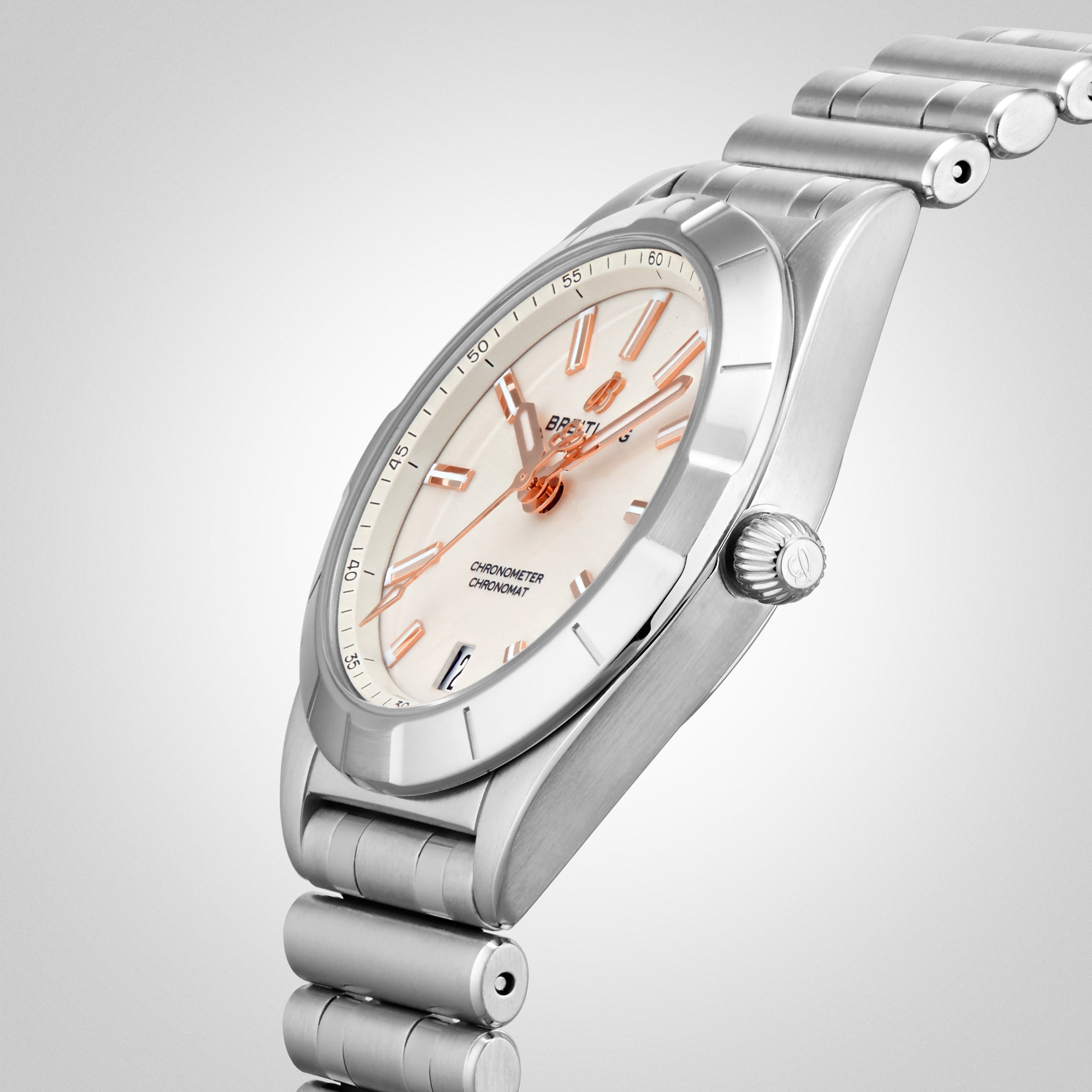 The Breitling Chronomat 32 is a stainless steel wristwatch with a cream dial, rose gold hands and hour markers, and a signature Rouleaux bracelet, displayed at an angle on a light background.