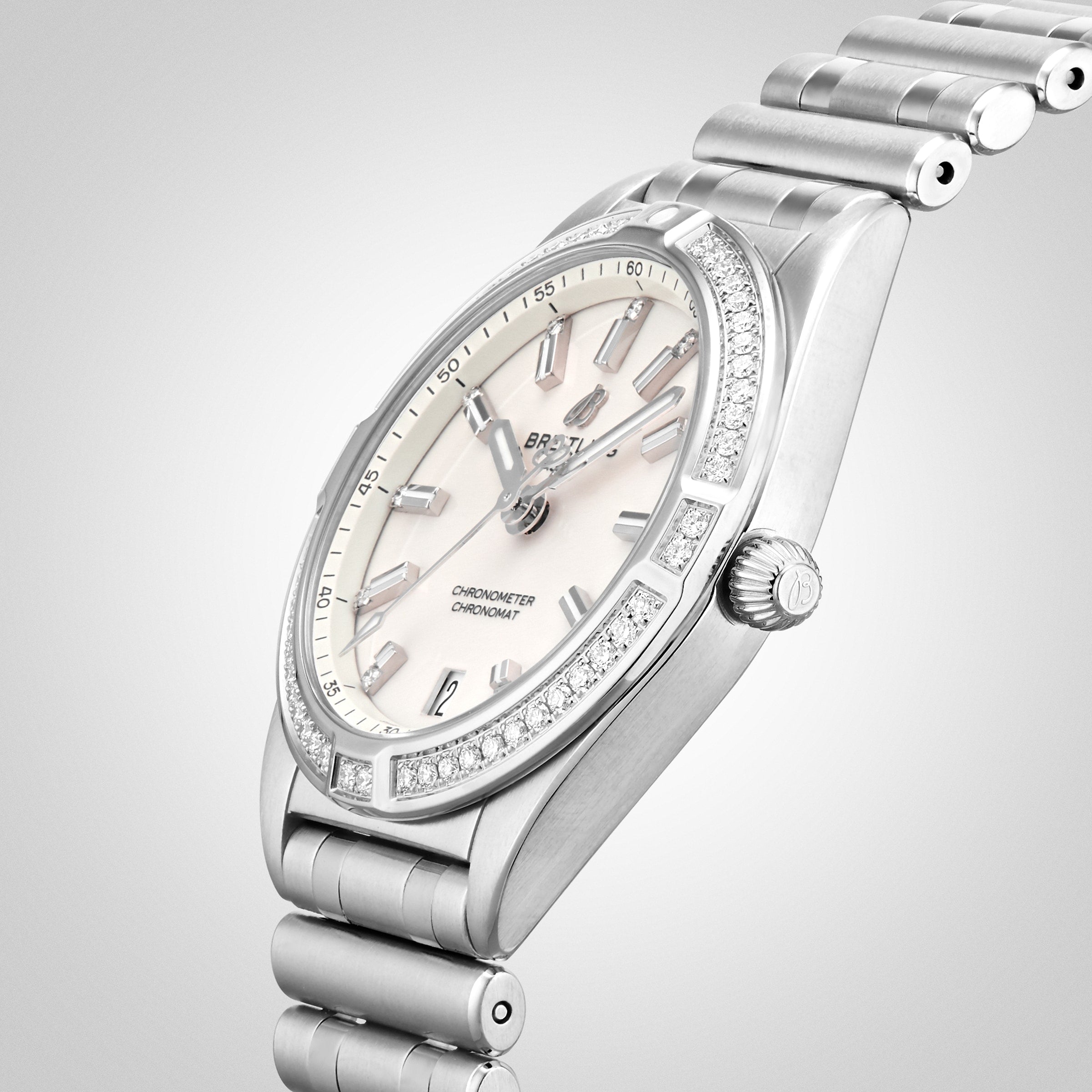 The Breitling Chronomat 32 is a silver wristwatch with a Rouleaux bracelet, diamond-accented bezel, and a light dial featuring silver hour markers and hands.
