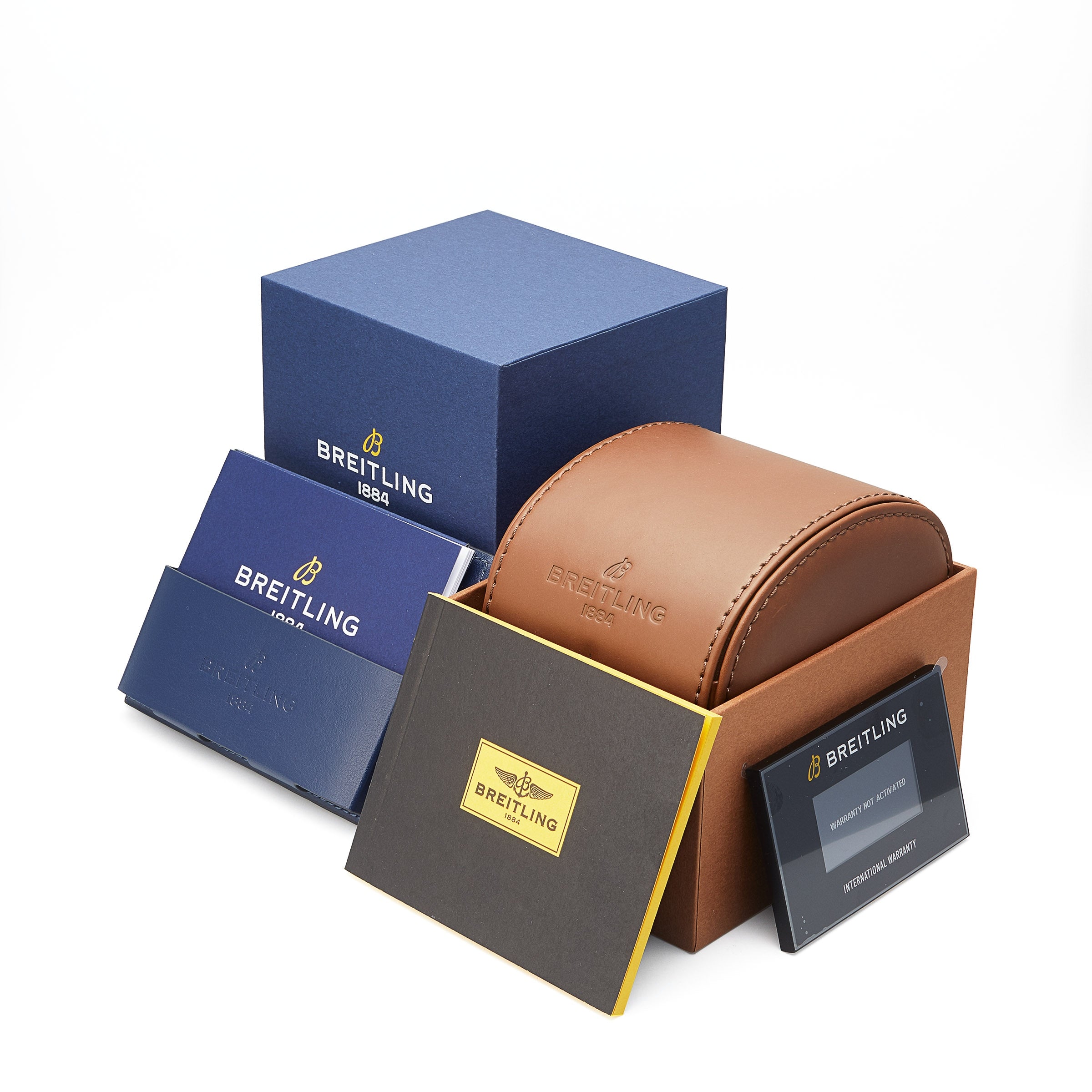Breitling Chronomat 32 packaging includes blue and brown boxes, a leather case, booklets, and a COSC-certified chronometer warranty card arranged neatly on a white background.