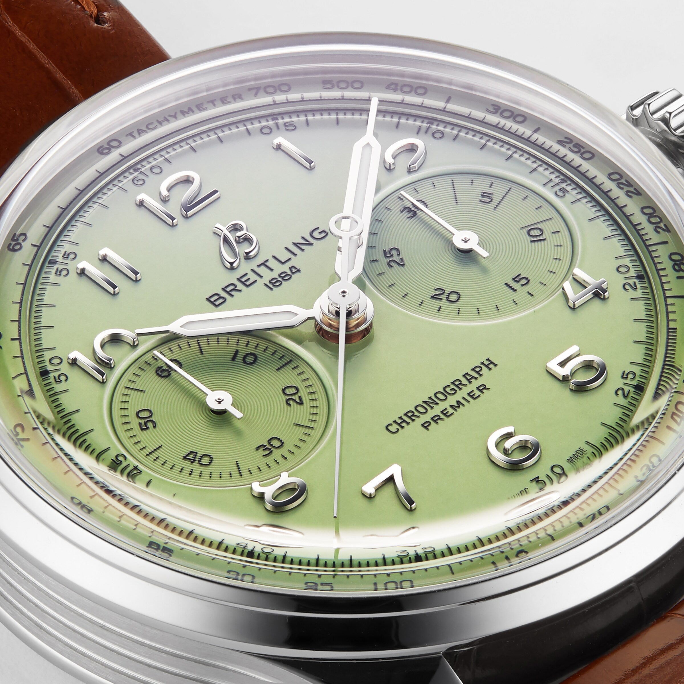 Close-up of the Breitling Premier B09 Chronograph 40, featuring a green dial, silver indices, three subdials, and a brown leather strap, powered by the B09 calibre movement.