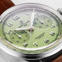 Close-up of the Breitling Premier B09 Chronograph 40, featuring a green dial, silver indices, three subdials, and a brown leather strap, powered by the B09 calibre movement.