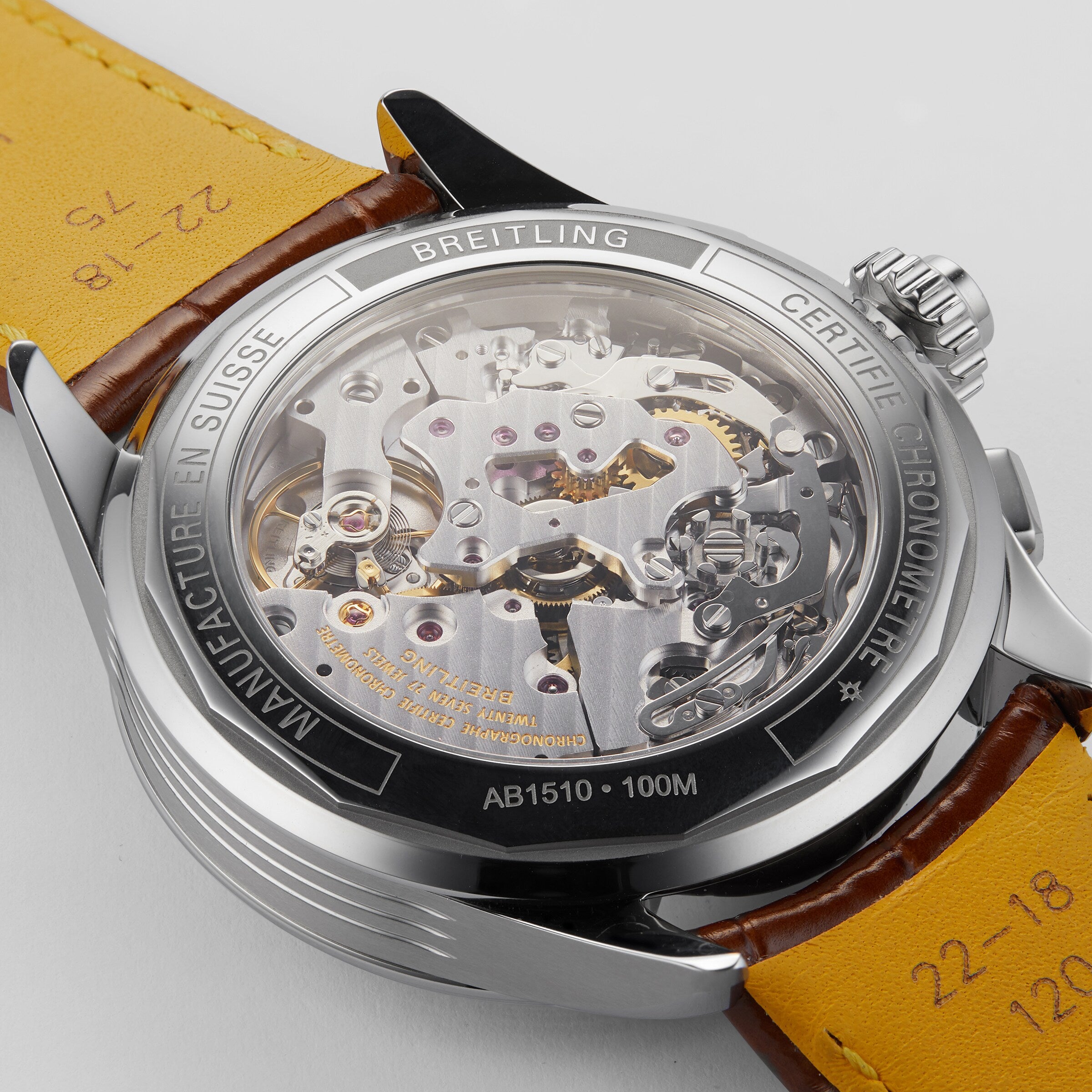 Close-up of the back of a Breitling Premier B15 Duograph 42, revealing its COSC-certified movement through a transparent case back and engraved details on the metal rim.