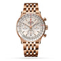 The Breitling Navitimer B01 Chronograph 41 is a rose gold watch with a link bracelet, silver dial, three subdials, red accents on the chronograph hand and scale, and is powered by the precise Breitling 01 calibre.