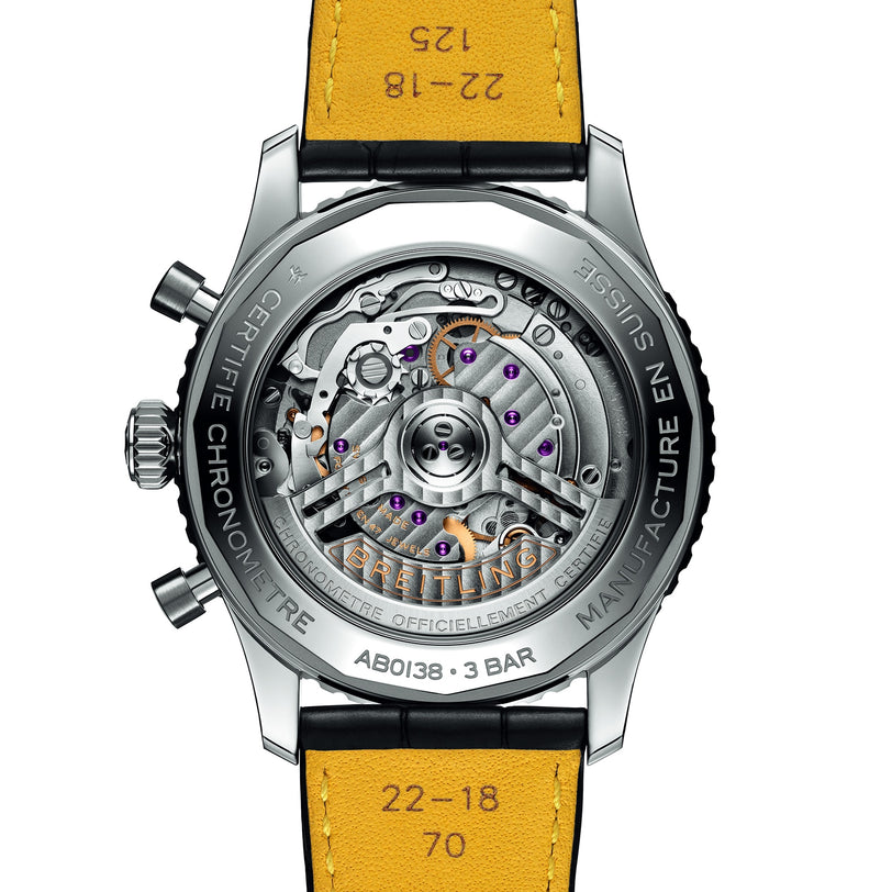 Close-up of the back of a Breitling Navitimer B01 Chronograph 43, revealing its exposed mechanical movement, labeled parts, and a yellow leather strap marked with printed numbers.