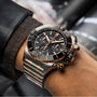 A close-up of a wrist wearing the Breitling Super Chronomat B01 44, a COSC-certified chronograph with a black dial, 18ct rose gold accents, and a two-tone metal bracelet.