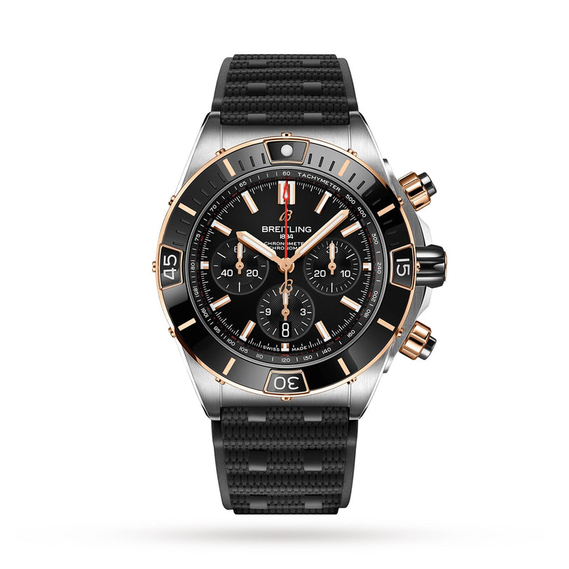 Breitling Super Chronomat B01 44 mechanical chronograph with a black and gold bezel, black dial with three subdials, date window at 6 oclock, and a textured black strap.