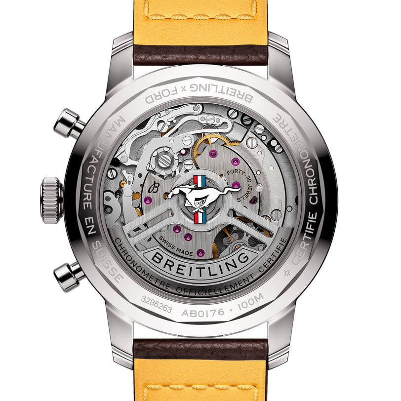 Close-up of the transparent case back on the Breitling Top Time B01 Ford Mustang, revealing the intricate Breitling Manufacture Calibre 01 movement with labeled components and a yellow and brown leather strap.