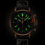 The Breitling Top Time B01 is a black watch featuring glowing green hour markers and a black leather strap.
