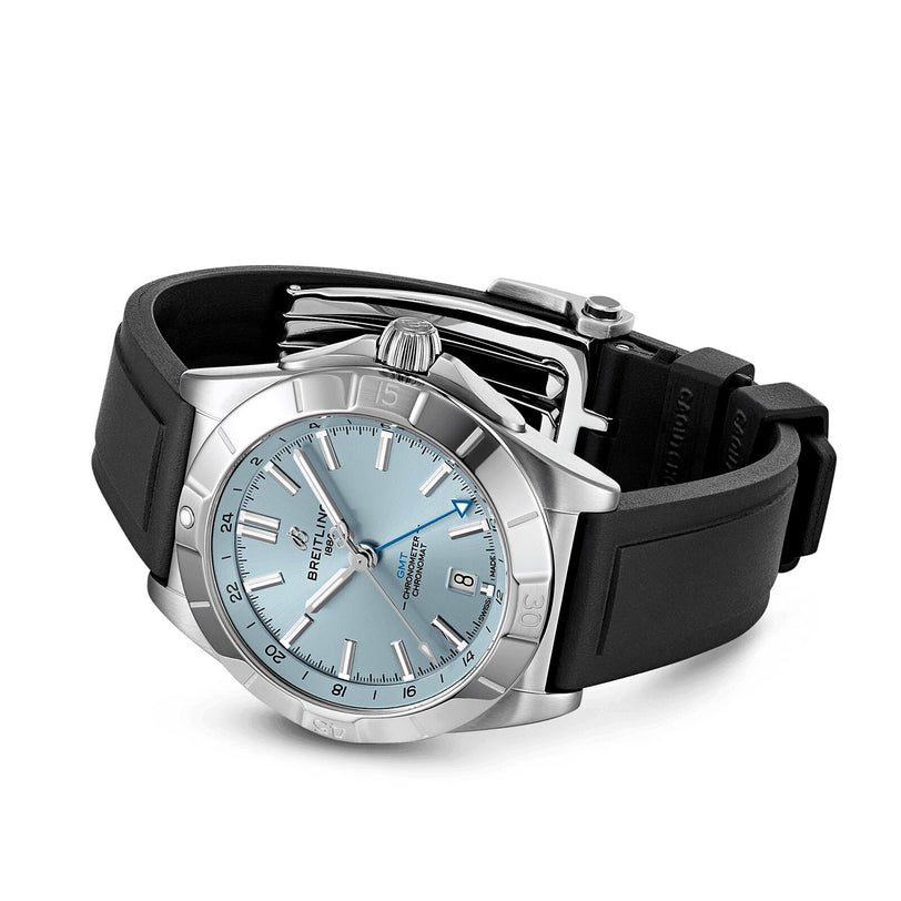 The Breitling Chronomat Automatic GMT 40 is a stainless steel sports watch featuring a light blue dial, dual time zone, date display, and a black rubber strap, shown on a white background.