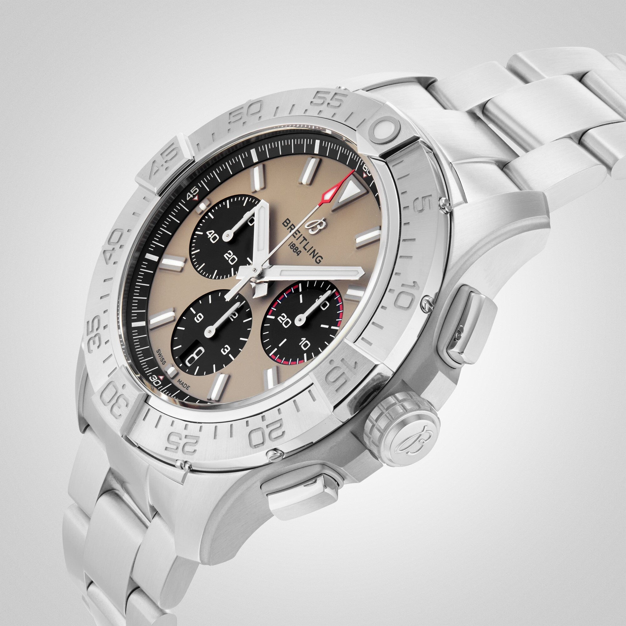 The Breitling Avenger B01 Chronograph 44 features a stainless steel case, beige dial with black subdials, silver metal bracelet, and Breitling 01 calibre movement, shown at an angle on a light background.
