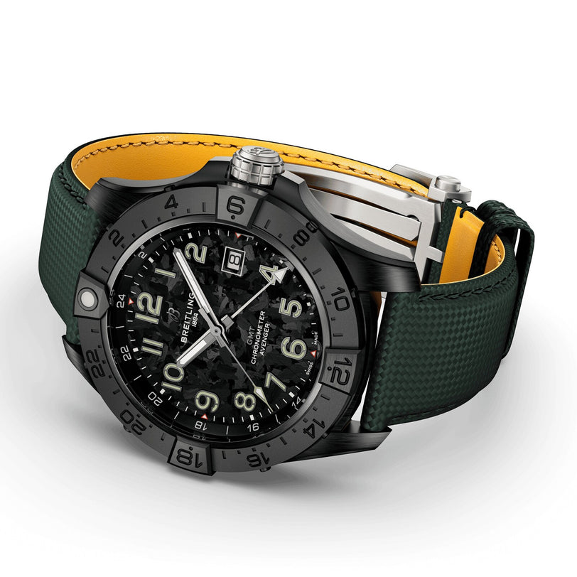 The Breitling Avenger Automatic GMT 44 Night Mission wristwatch features aviation-inspired design, a black case, large numerals, date display, rugged bezel, a textured green strap with yellow lining, and is displayed at an angle.