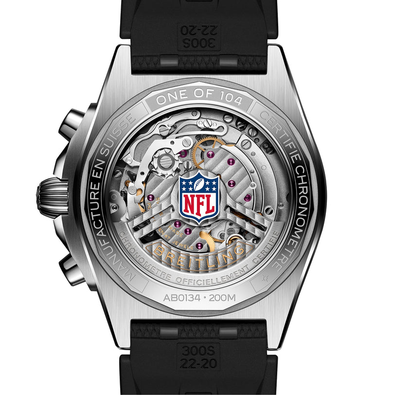 Close-up of the Breitling Chronomat B01 42 NFL Atlanta Falcons Edition watch back, showing visible gears, engraved text, and the NFL logo on a metal and black rubber timepiece.