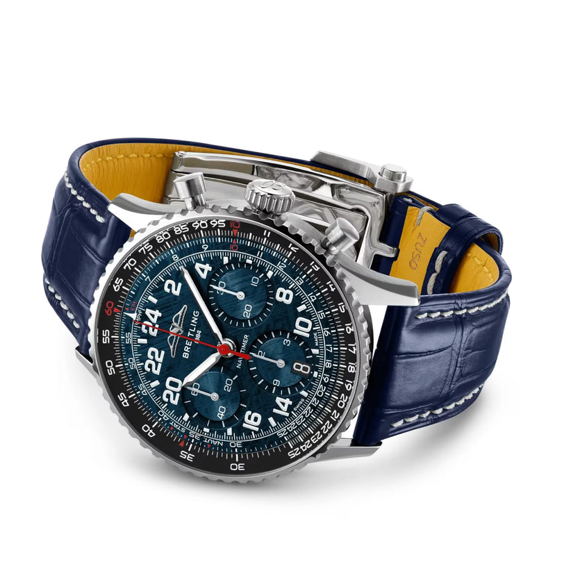 Stainless steel chronograph watch with dark blue dial, subdials, and navy leather strap with yellow interior lining.