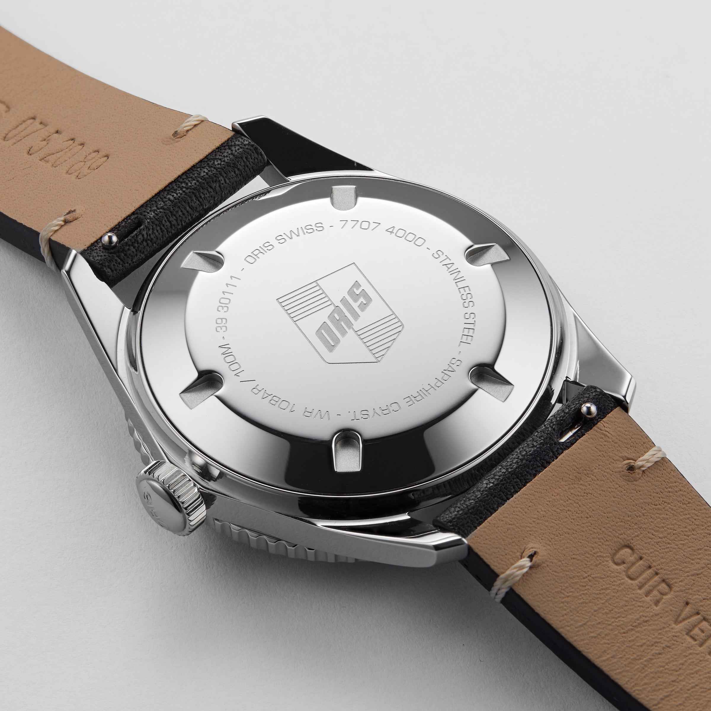 Close-up of the Oris Divers Sixty‑Five wristwatch back, featuring engraved details and a leather strap.