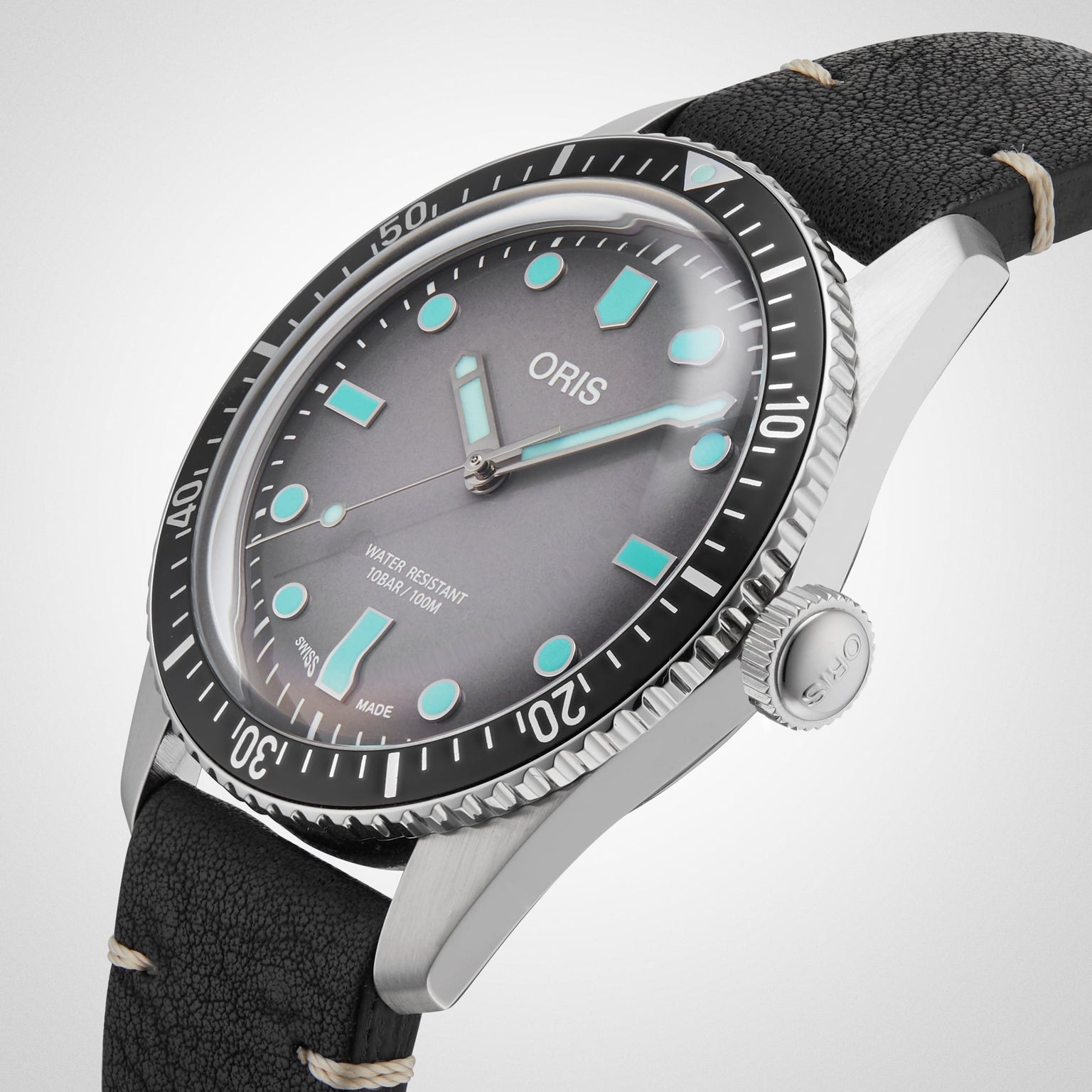 An Oris Divers Sixty‑Five wristwatch featuring a silver case, black leather strap, and turquoise hour markers set against a white dial.