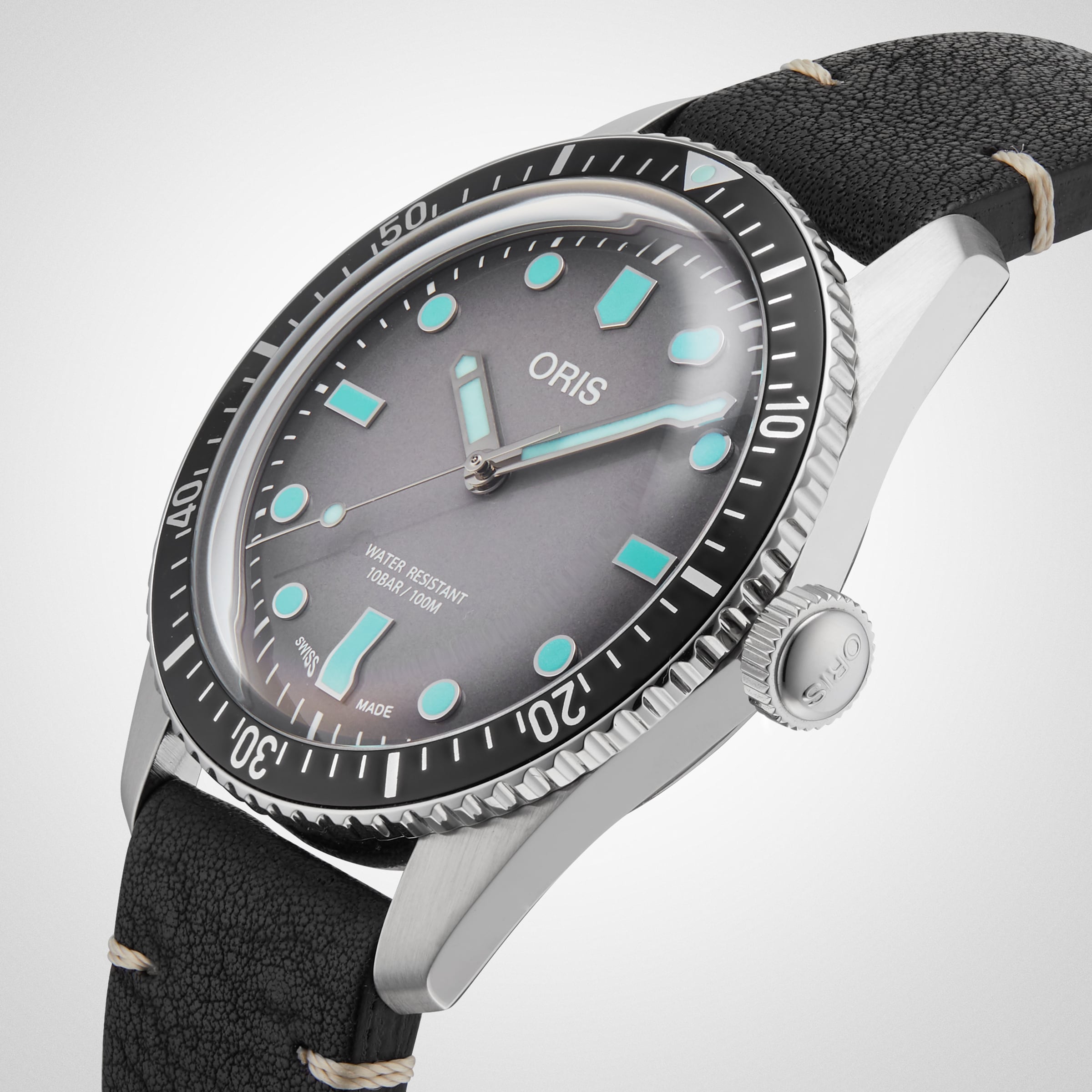 An Oris Divers Sixty‑Five wristwatch featuring a silver case, black leather strap, and turquoise hour markers set against a white dial.