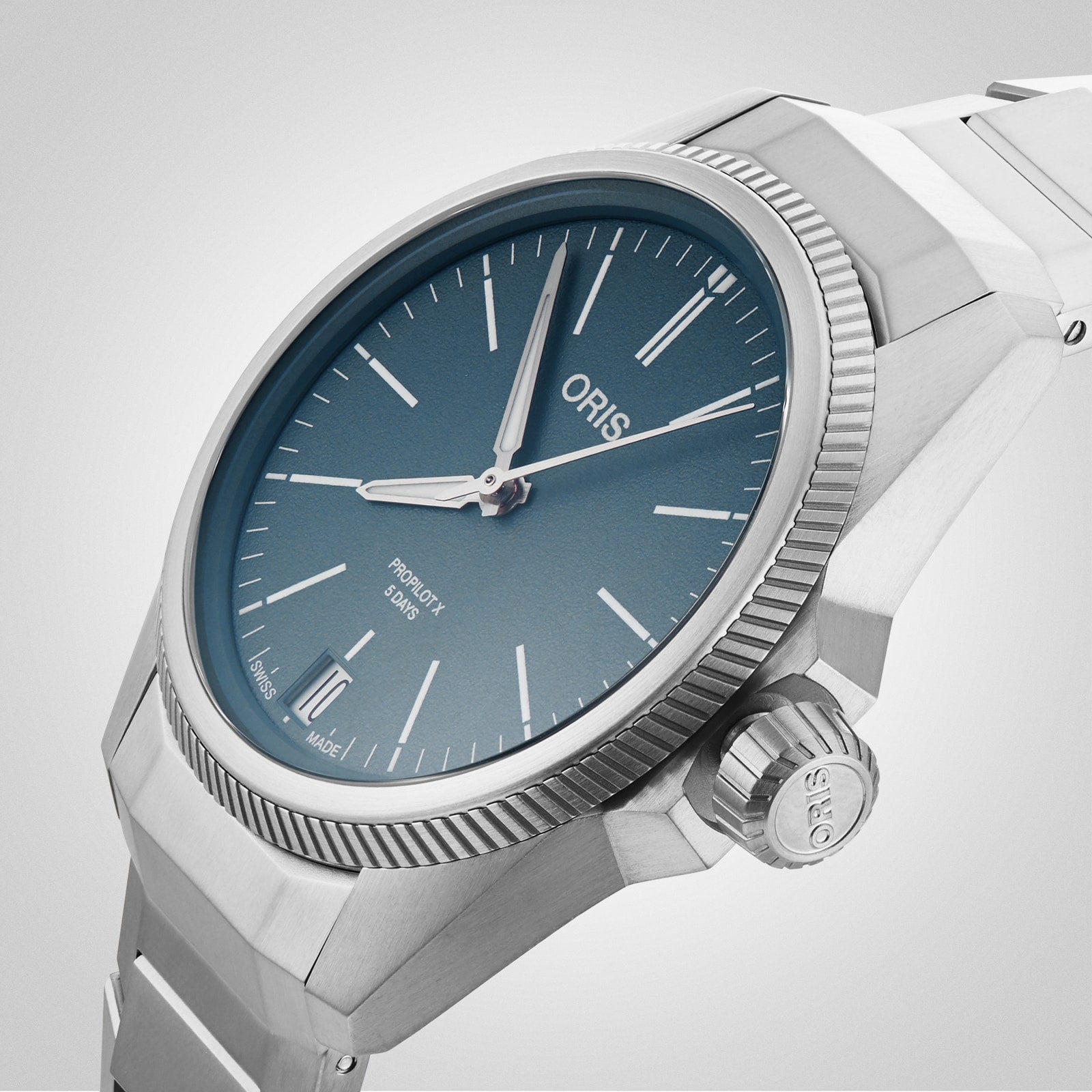Close-up of the Oris ProPilot X Calibre 400 watch, showcasing aviation-inspired stainless steel construction, a blue dial with silver markers, date at 6 o’clock, and a metal bracelet.
