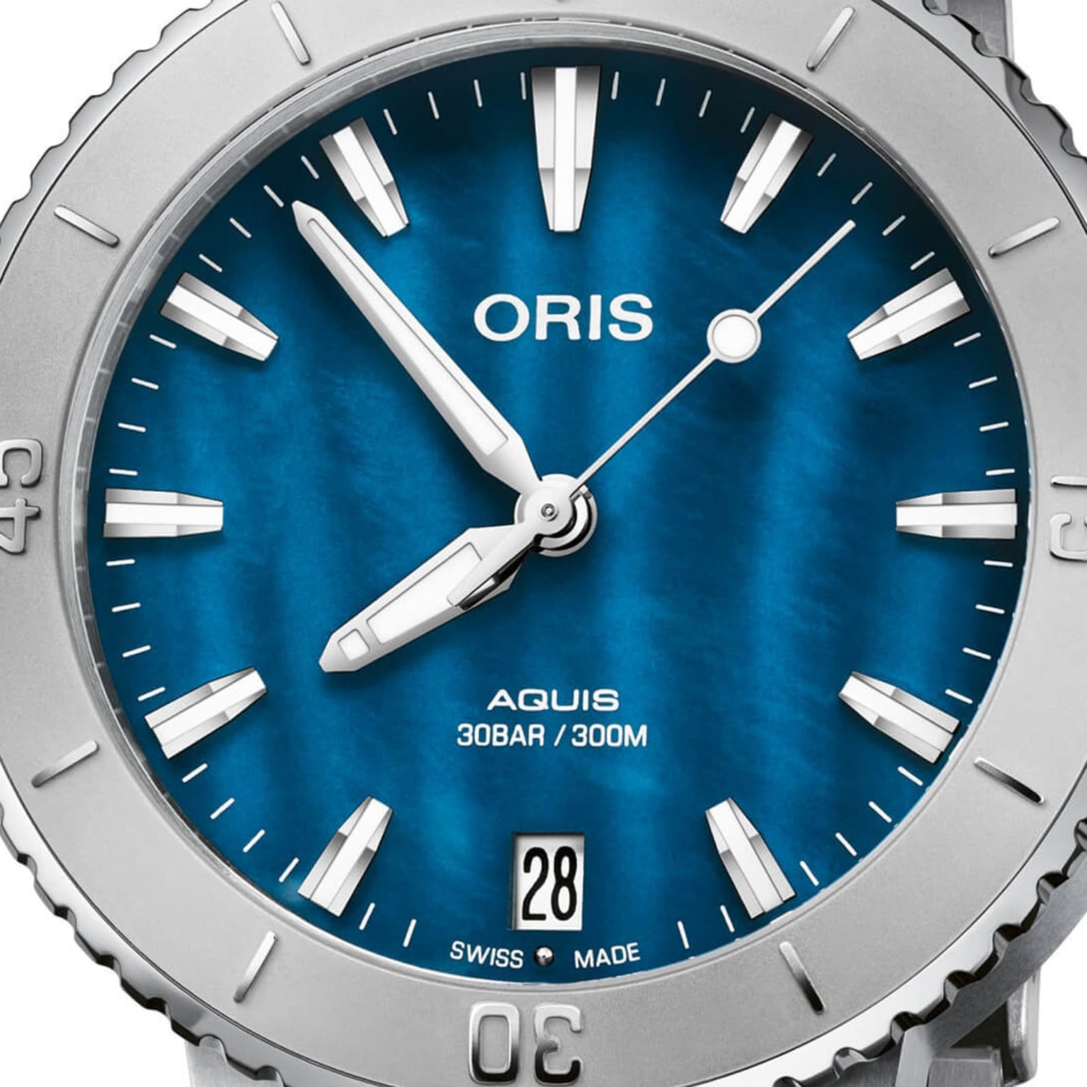 Close-up of the Oris Aquis Date watch featuring a blue dial, silver markers and hands, a date window at 6 o’clock, and water resistance up to 30 bar (300 meters).