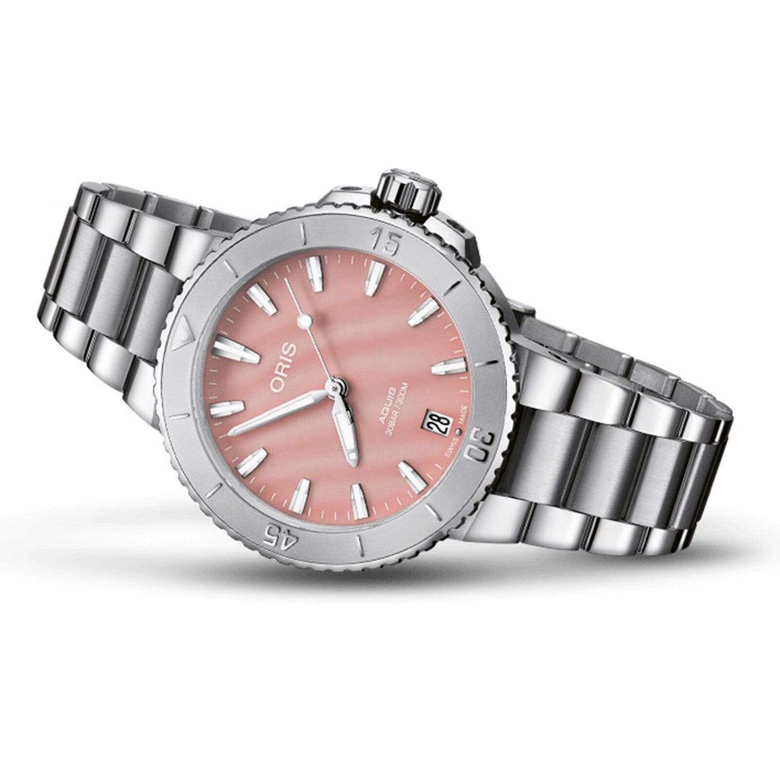 The Oris Aquis Date is a stainless steel diver’s watch with a blush pink dial, white hour markers, date window at 6 o’clock, and a sleek silver metal bracelet.