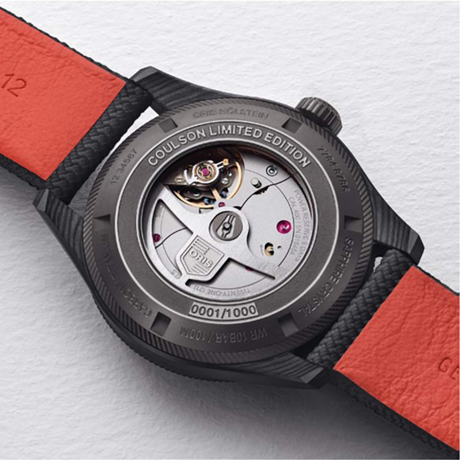 Close-up of the back of an Oris ProPilot Coulson Limited Edition wristwatch with 3D printed carbon fibre case, numbered 0001/1000, featuring mechanical movement and a black and red strap.