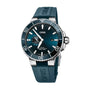 The Oris Aquis Small Second Date is a blue divers watch with a stainless steel case, teal rubber strap, and a blue gradient dial with Super-LumiNova hands. It displays the time at 10:09 and the date at 3 o’clock.