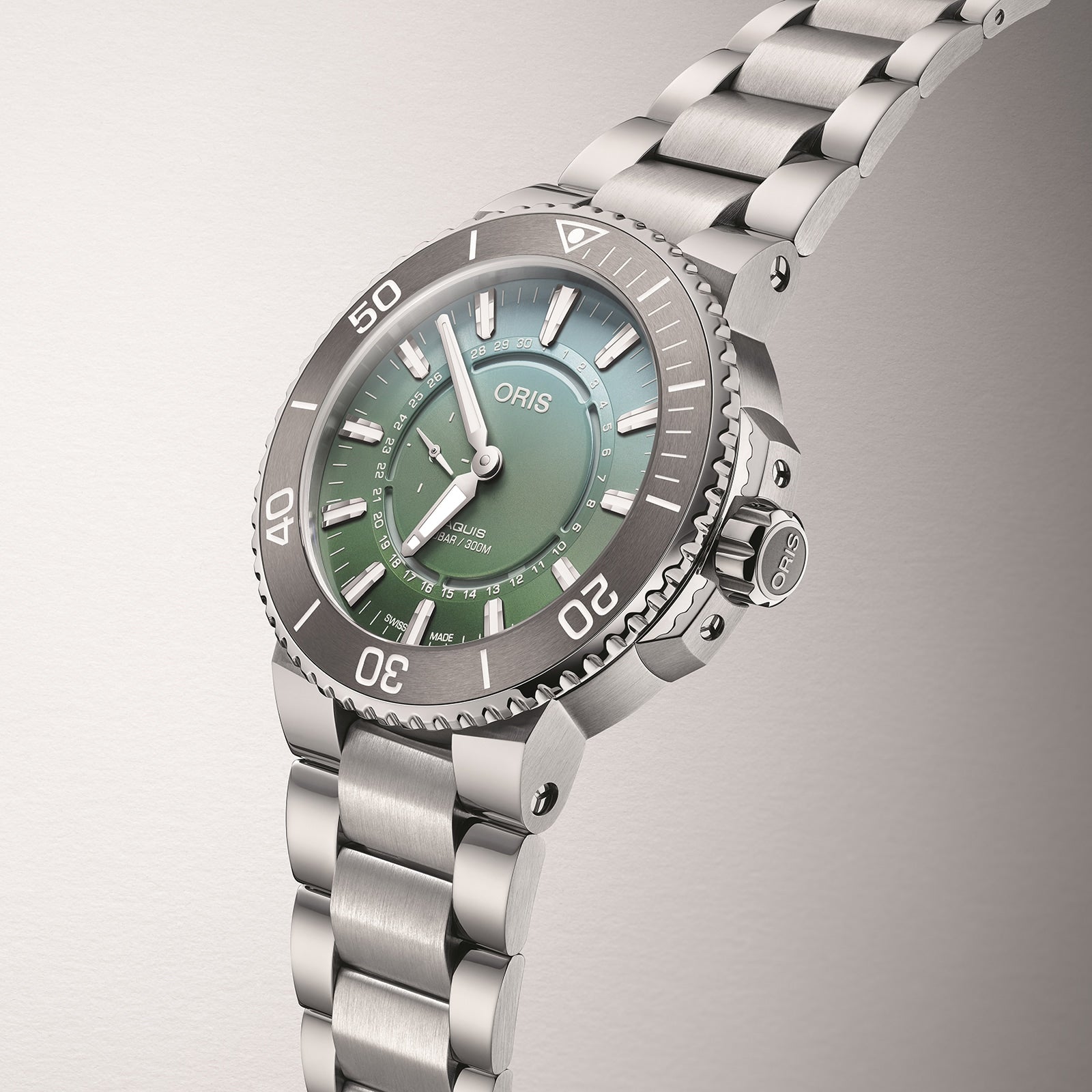 The Oris Dat Watt Limited Edition II is a stainless steel watch with a green dial, luminous markers, unidirectional bezel, and metal bracelet, inspired by Wadden Sea conservation and shown against a neutral background.