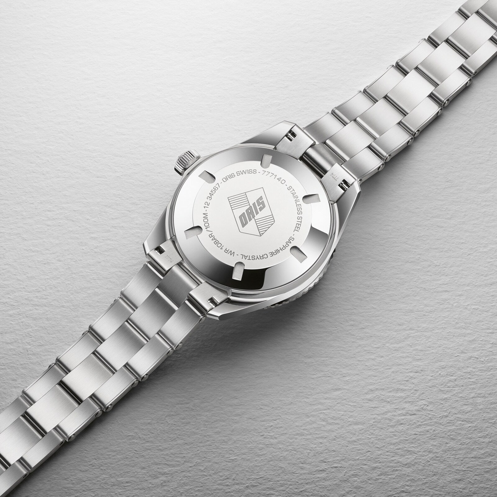 The Oris Divers Sixty‑Five Cotton Candy is a silver wristwatch with a metal band, shown from the back to display the Oris logo and engraved details.