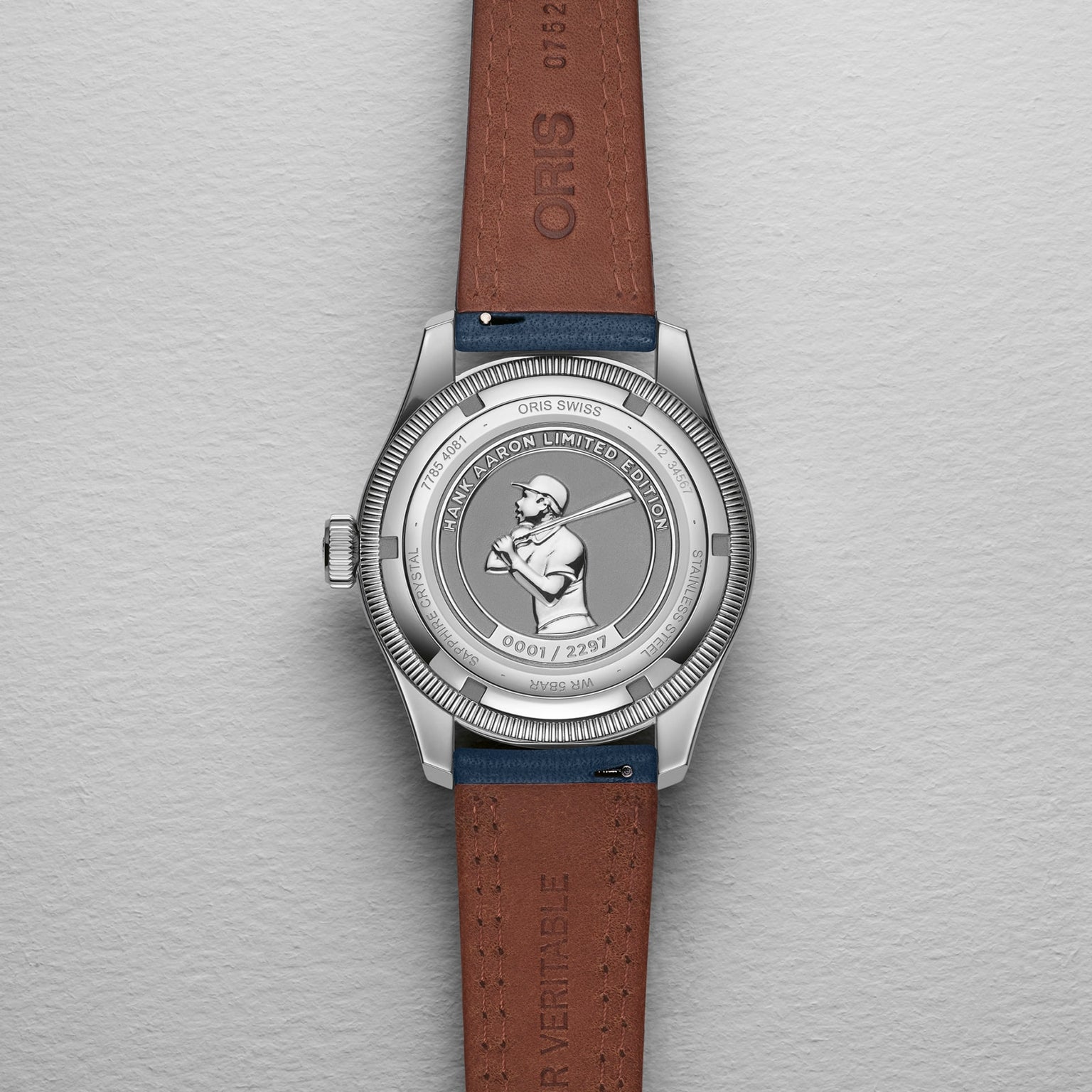 The Oris Big Crown Hank Aaron Limited Edition watch features a stainless steel case with an engraved baseball player, Limited Edition and serial number on the back, paired with a brown leather strap.