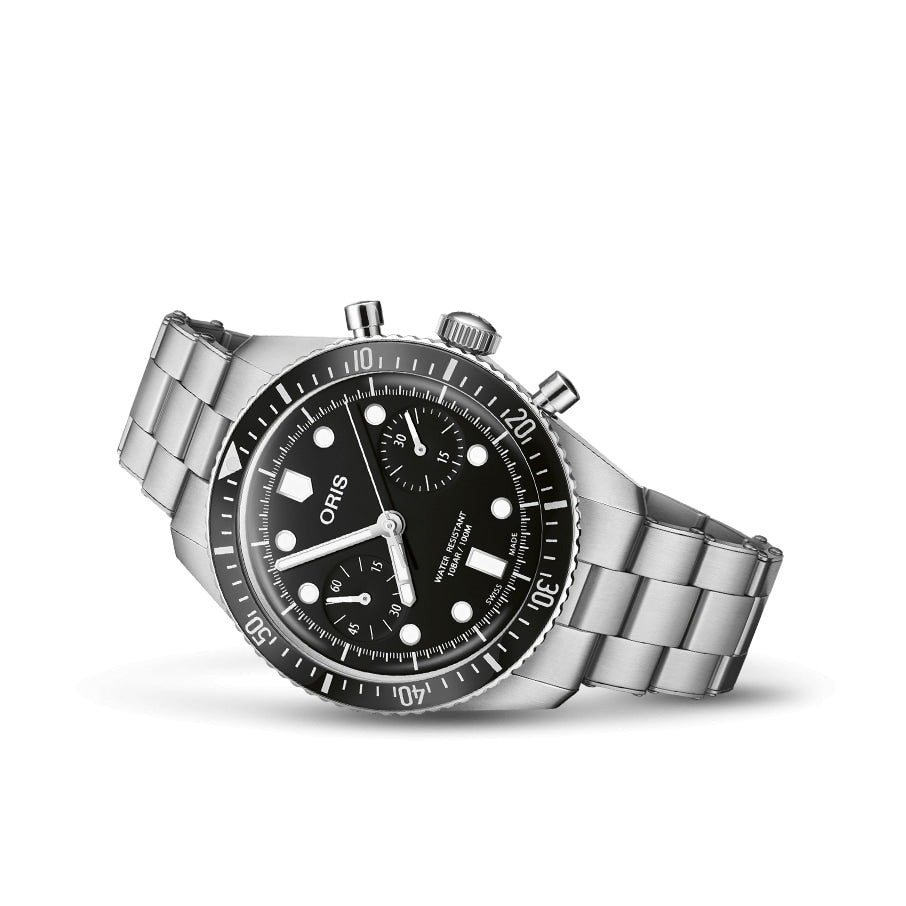 An Oris Divers Sixty‑Five Chronograph wristwatch with a silver case, black dial, metal band, and three sub-dials shown on a white background.
