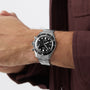 A person wearing the Oris Divers Sixty‑Five Chronograph with a black dial and a maroon long-sleeve shirt.
