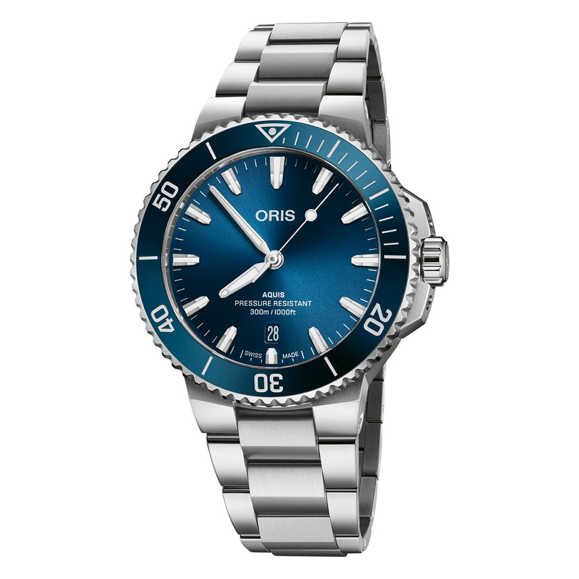 The Oris Aquis Date is a Swiss Made dive watch featuring a blue dial and bezel, silver hour markers, date display at 6 o’clock, automatic movement, and a stainless steel bracelet.