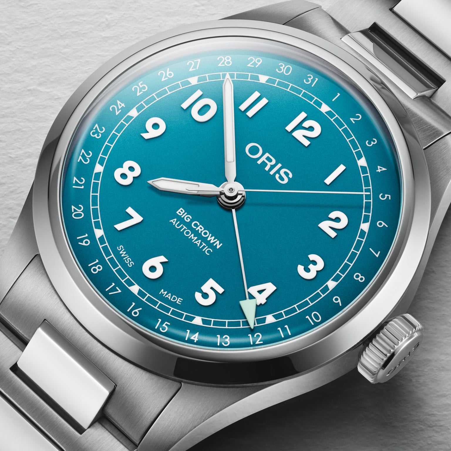 A close-up of the Oris Big Crown Pointer Date wristwatch in silver, featuring a blue dial with white numerals, displaying the time at 4:42.