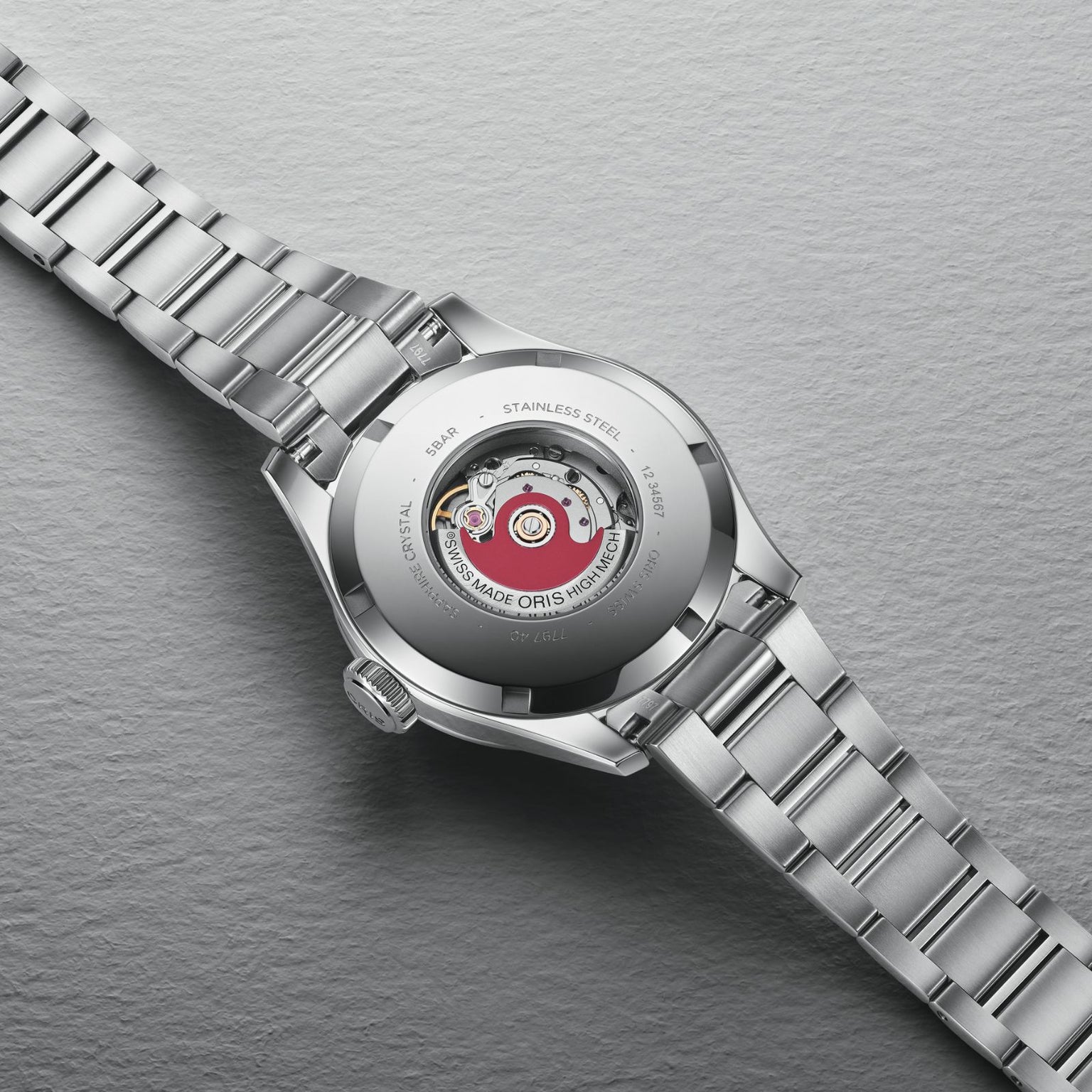 A close-up of the back of the Oris Big Crown Swiss Made stainless steel watch, showcasing its exposed mechanical movement and engraved automatic details.