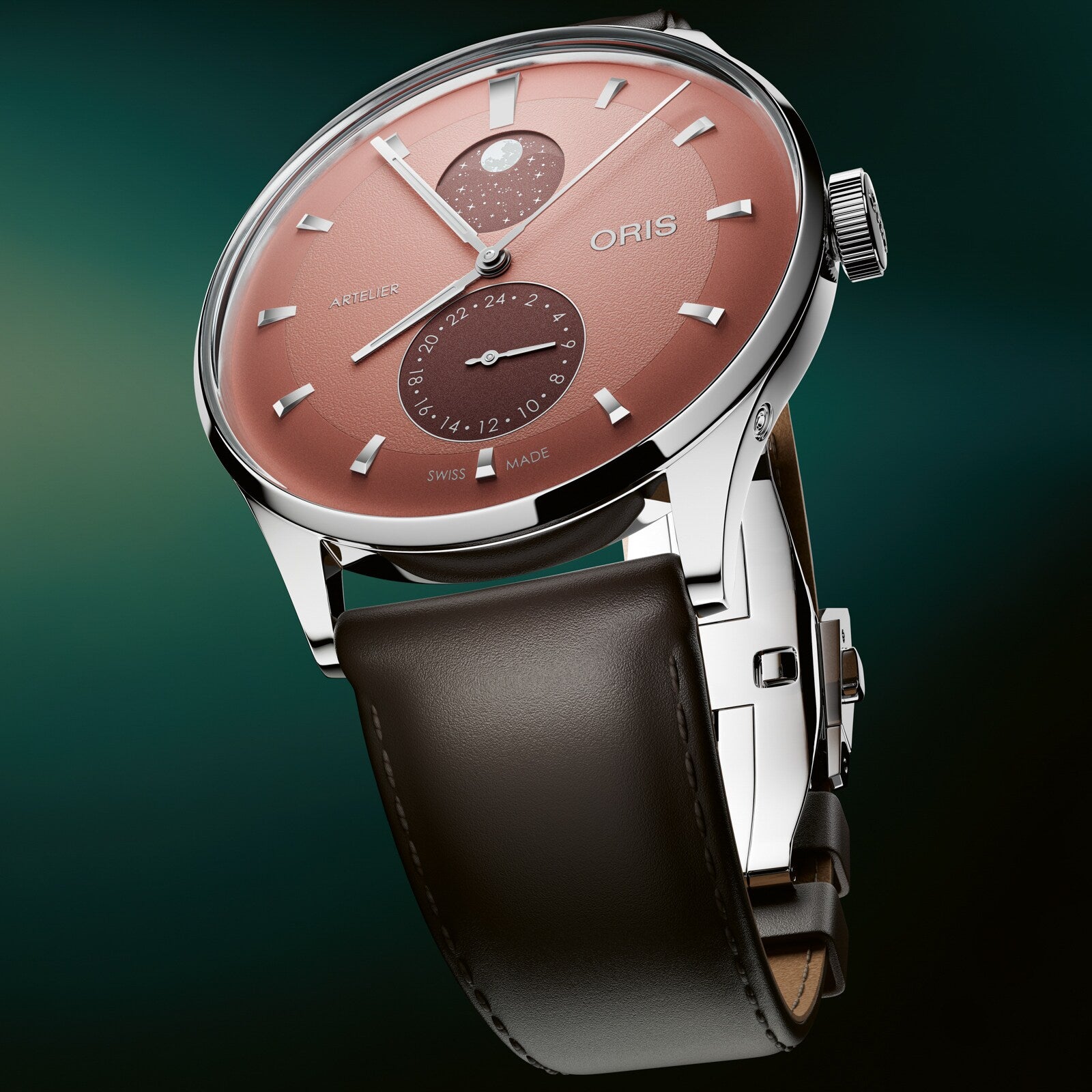 Silver-cased watch with coral dial, moonphase subdial, date ring, and brown leather strap.