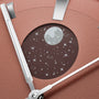 Circular brown watch face with full moon and star embellishments on pink leather strap with silver metal hardware.
