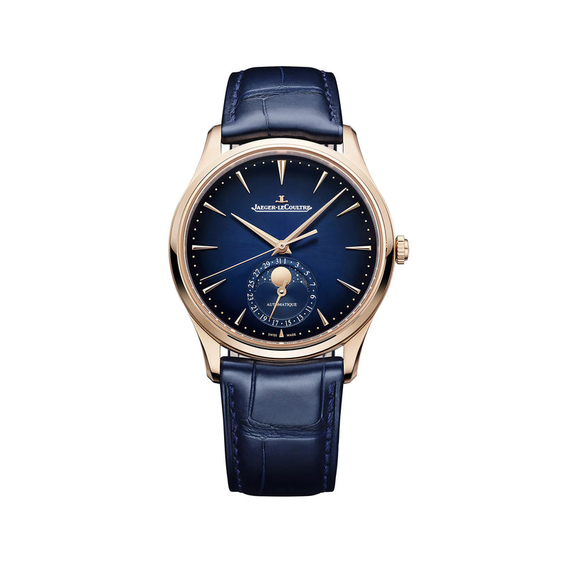 The Jaeger-LeCoultre Master Ultra Thin Moon Navy pairs a blue leather strap with a gold case and blue dial, showcasing gold hour markers, slender hands, and a moon phase subdial with date at 6 o’clock—true elegance.