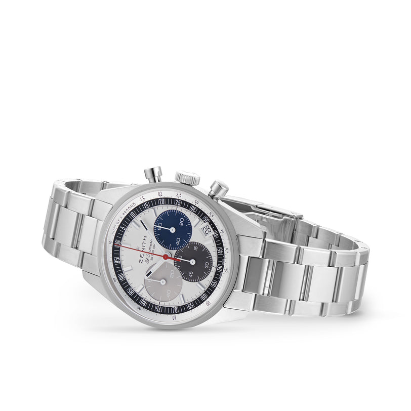 The Zenith Chronomaster EP Original features a stainless steel case, silver band, white dial with blue, gray, and silver sub-dials, and a red second hand—its angled display pays tribute to the iconic El Primero A386 design.