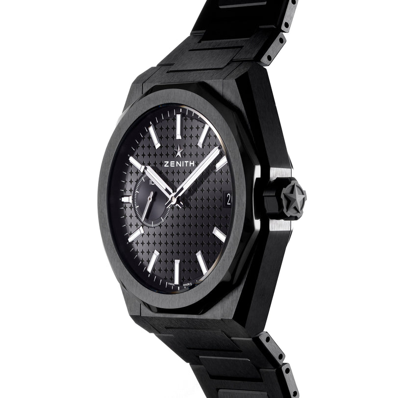 The Zenith Defy Skyline wristwatch in black ceramic features a textured dial, white hour markers, a date window at 3 o’clock, and a subdial at 9 o’clock, displayed at a slight angle.