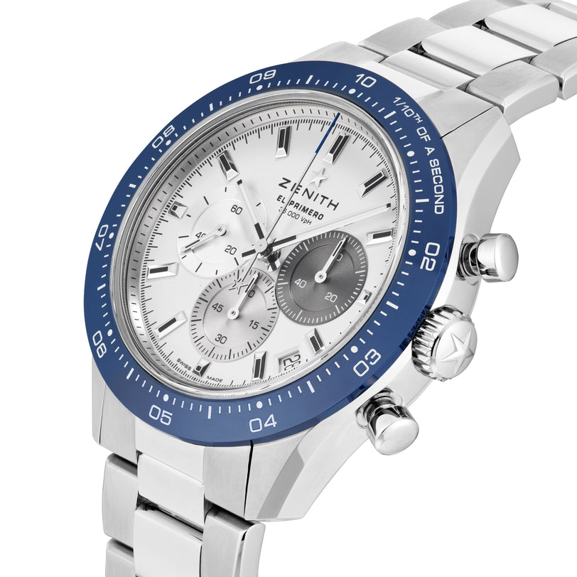 The Zenith Chronomaster Sport Centenary Exclusive features a stainless steel case, blue bezel, silver bracelet, three subdials, and silver hour markers—available at Watches of Switzerland.