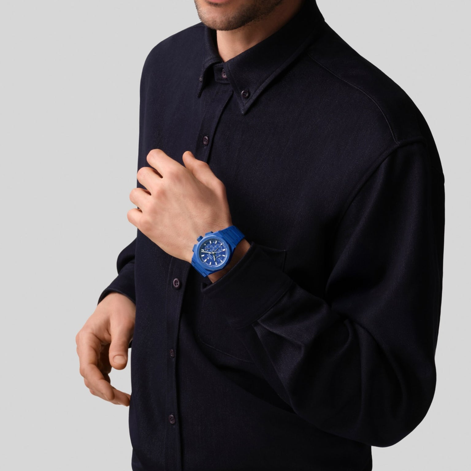 A person in a dark button-up shirt wears the Zenith Limited Edition Defy Skyline Chronograph 160th Anniversary Edition on their left wrist against a plain light background, highlighting its El Primero 3600-powered elegance.