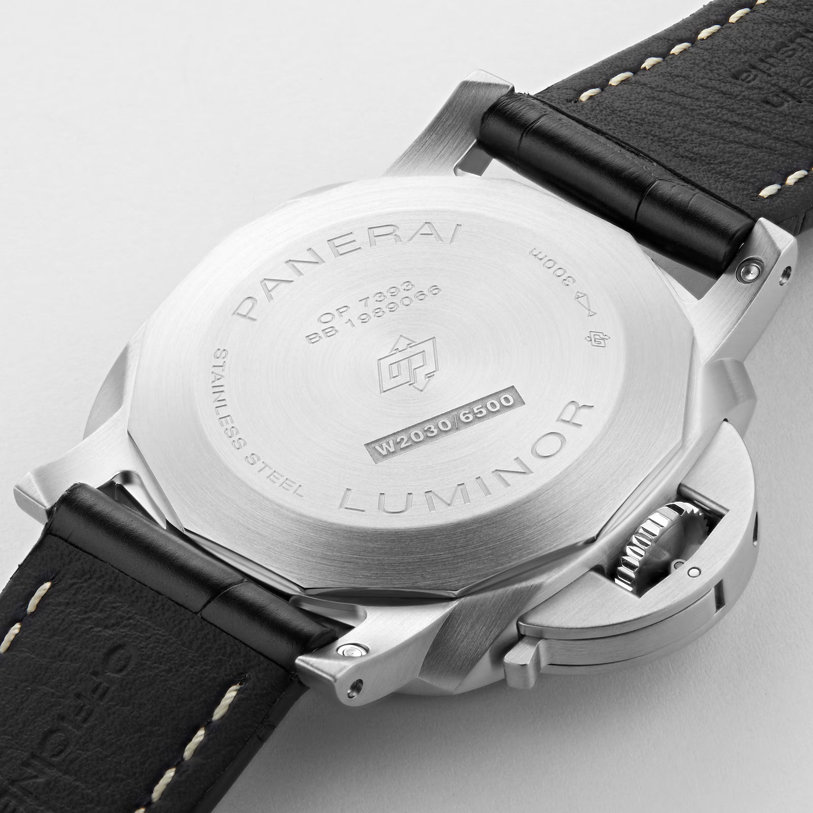 Close-up of the back of a Panerai Luminor Marina wristwatch, showing engraved details on the stainless steel case, black leather strap with white stitching, and a partially visible crown guard.