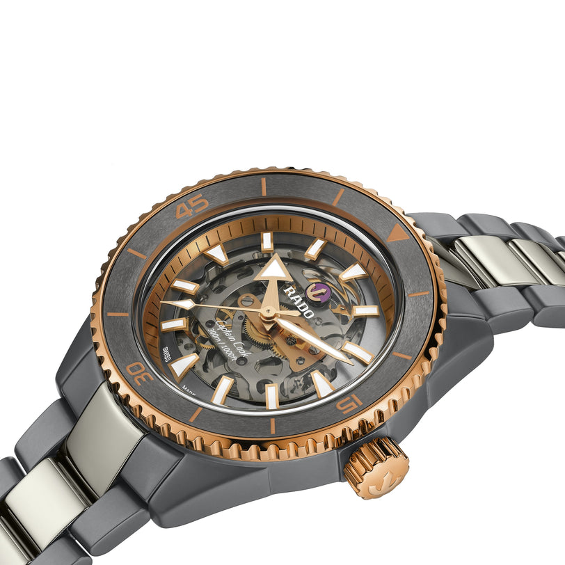 A close-up of the Rado Captain Cook High-Tech Ceramic Skeleton, featuring a metal band, rose gold accents, and a transparent skeleton dial that reveals the intricate R808 movement and internal gears.