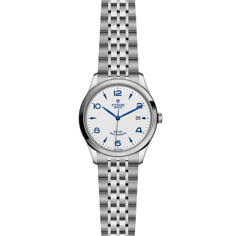The TUDOR 1926 is a stainless steel men’s watch with a silver link bracelet, white dial, blue Arabic numerals, date at 3 o’clock, and TUDOR branding below 12—ideal for lovers of classic mechanical watches.