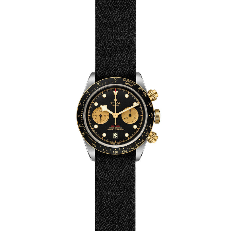 The TUDOR Black Bay Chrono S&G features a black fabric strap, black face, three gold subdials, gold pushers and crown, and a black and gold bezel—blending iconic chronograph diver’s watch design with signature TUDOR style.