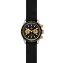 The TUDOR Black Bay Chrono S&G features a black fabric strap, black face, three gold subdials, gold pushers and crown, and a black and gold bezel—blending iconic chronograph diver’s watch design with signature TUDOR style.