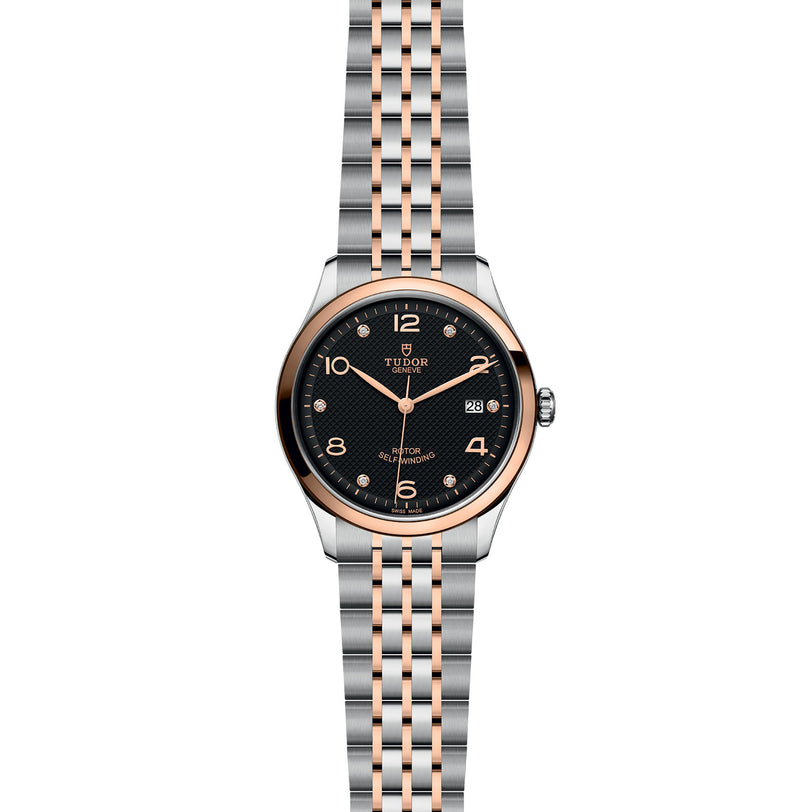 The TUDOR 1926 is a classic wristwatch featuring a black dial, gold hour markers, date display, and a two-tone silver and gold bracelet—ideal for fans of refined mechanical watches.