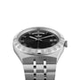 A TUDOR Royal watch in silver with a black dial, Roman numerals, and a stainless steel bracelet.
