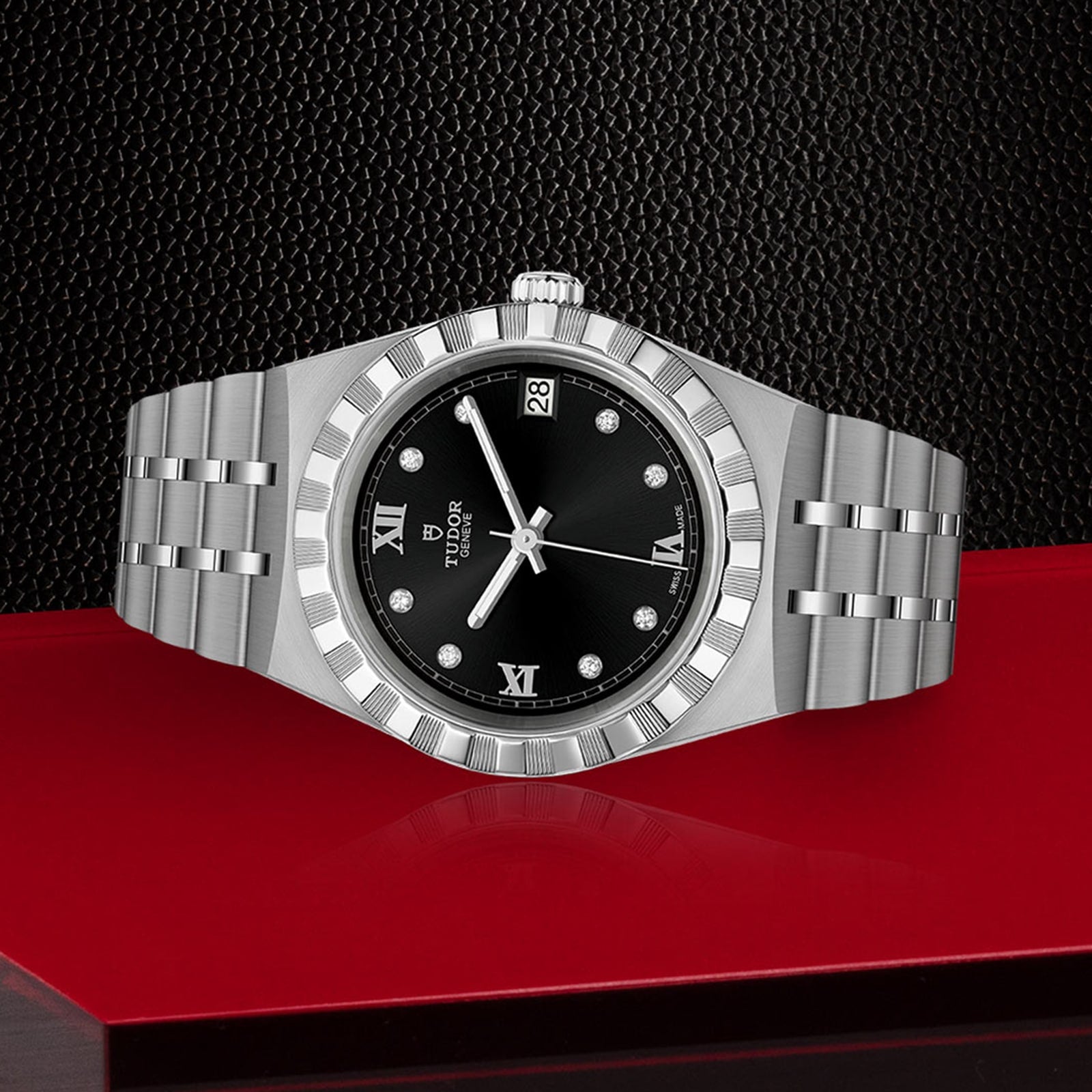 The TUDOR Royal wristwatch features a black dial with Roman numerals, diamond hour markers, and a date window, plus an integrated bracelet. Displayed against a textured black and red background.