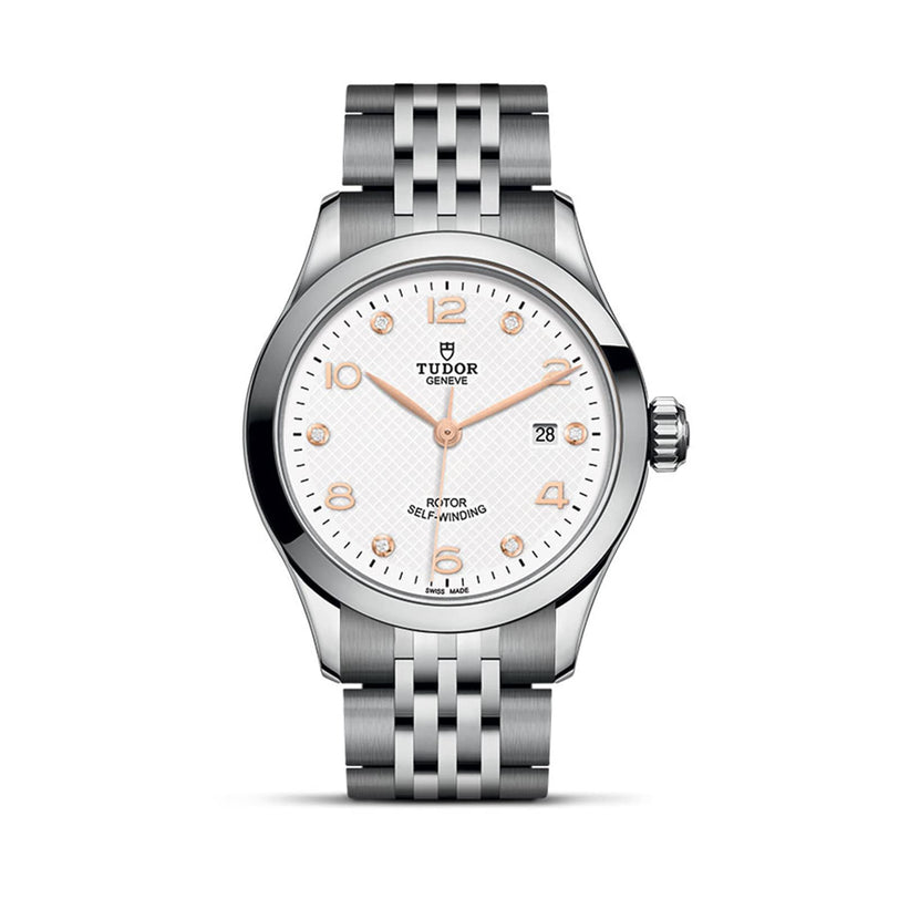 The TUDOR 1926 wristwatch features a silver metal bracelet, white textured dial, rose gold markers and hands, plus a date window at 3 o’clock—showcasing refined mechanical elegance.