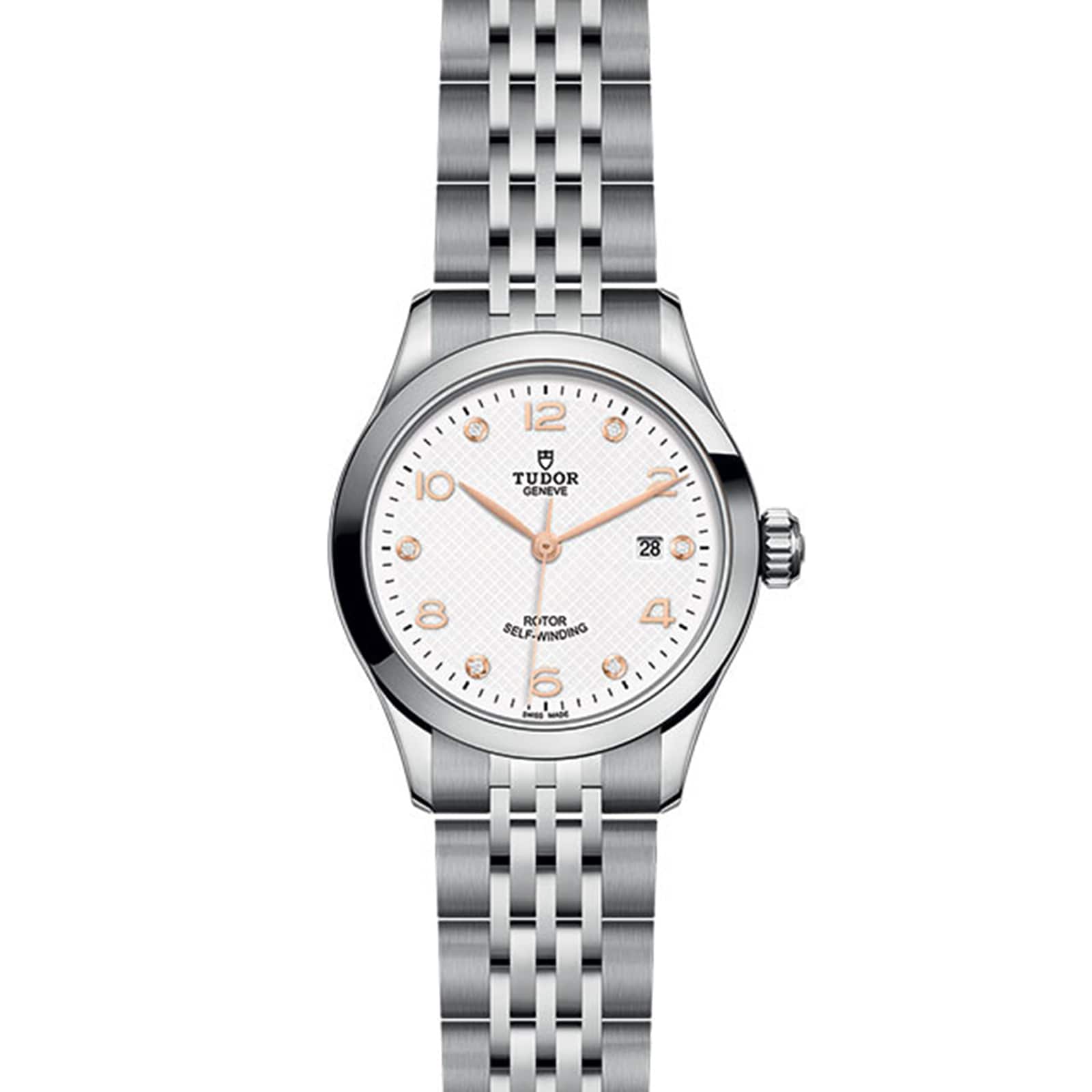 The TUDOR 1926 features a stainless steel case, white dial, silver hour markers, date at 3 o’clock, and metal link bracelet—an elegant tribute to TUDOR’s tradition of fine mechanical watches.